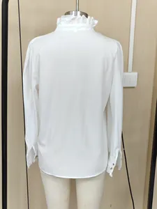 Detailed back view of elegant white long-sleeve shirt with ruffled collar on mannequin