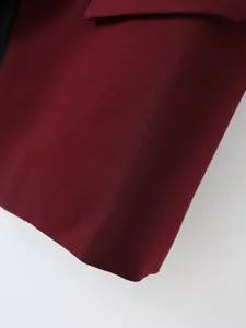 Primer plano de la tela texturizada y detalles de mangas plisadas del blazer burdeos