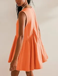 Detailed side view of a vibrant orange sleeveless pleated babydoll dress with pockets