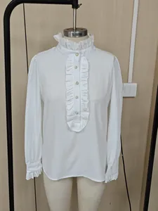Close-up of white elegant long sleeve shirt with ruffle collar and pearl buttons