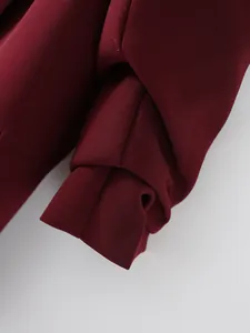 Primer plano de un blazer color burdeos con elegantes detalles de mangas plisadas