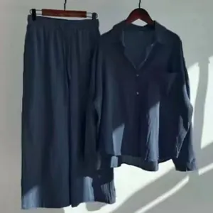 Dettaglio del set vintage in cotone lino camicia e pantaloni larghi a vita alta blu