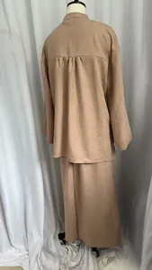 Rear view of the beige linen-like two-piece set showing elegant pleated back detail