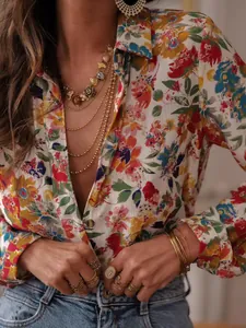 Detail shot of vibrant floral print long-sleeved shirt with chic gold jewelry styling.