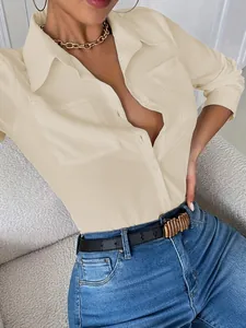 Primer plano de elegante camisa beige con solapa, bolsillos y accesorios