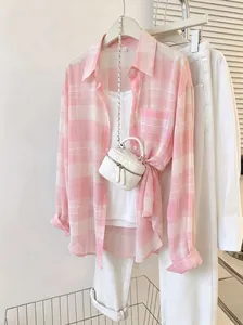 Close-up of pink plaid chiffon sun protection shirt with white tank top and pants