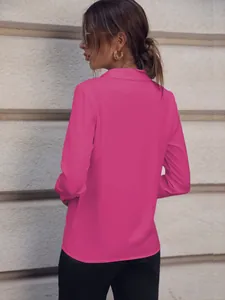 Vista trasera de una blusa rosa vibrante de manga larga para mujer con cuello clásico.