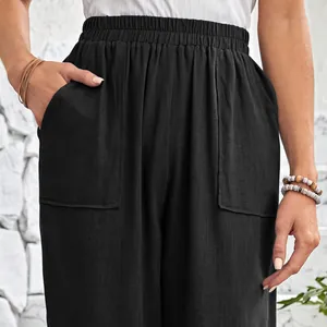 Detail view of black cotton linen trousers showing elastic waist and large pockets