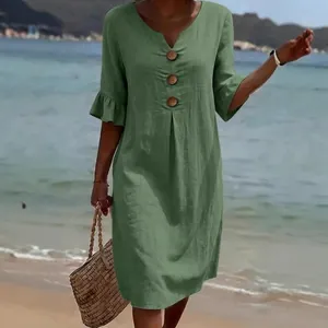 Green V-neck cotton linen dress with large decorative buttons and ruffle sleeves