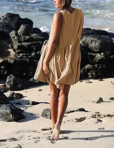 Detailed back view of a sleeveless khaki ruffled mini dress worn on a sunny beach