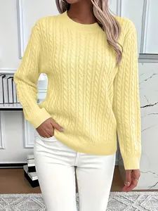 Detailed view of classic pale yellow cable-knit crew neck sweater worn by a model in interior