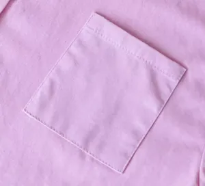 Dettaglio ravvicinato di una tasca quadrata su camicia in lino di cotone rosa con cuciture