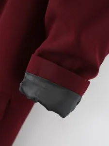 Vista detallada de la manga de un blazer burdeos para mujer con puño de forro negro