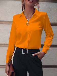 Vista detallada de una vibrante blusa naranja de manga larga para mujer estilo casual