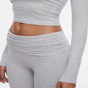 Close-up of grey long sleeve crop top and low waist yoga leggings in ribbed fabric