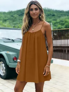Détail extérieur d'une robe marron plissée dos nu à bretelles pour les vacances à la mer