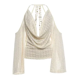 Detailweergave van elegante top met blote rug, gedrapeerde halslijn en decoratieve goudkettingen
