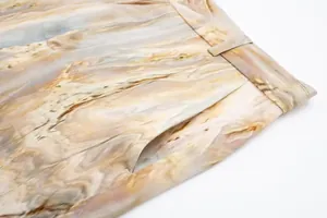 Vue détaillée du pantalon en satin de soie tie-dye, montrant la poche et les finitions de taille