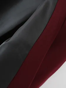 Detalle macro de la tela texturizada burdeos y el forro gris liso de la chaqueta