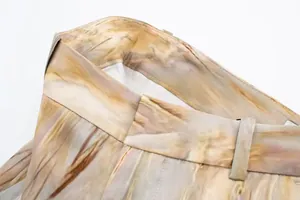 Gros plan de la taille d'un pantalon en satin tie-dye montrant coutures et texture.