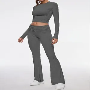 Full view of women's grey two-piece set featuring a crop top and flared leggings