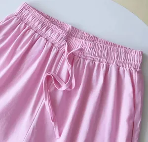 Primo piano dettagliato dei pantaloni rosa in cotone e lino con elastico e coulisse.