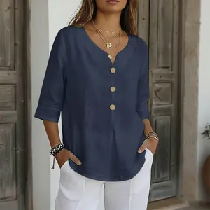 Dettaglio ravvicinato della camicetta estiva blu navy con bottoni in legno e scollo a V