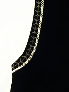 Macro dettagliata dei ricami con paillettes su un gilet in velluto nero di lusso