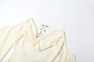 Detailopname van sexy gebreide top met open rug, metalen ketting en lovertjes.