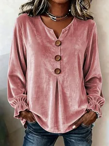 Gedetailleerde weergave van stoffig roze fluwelen blouse met V-hals en knoopdetails.
