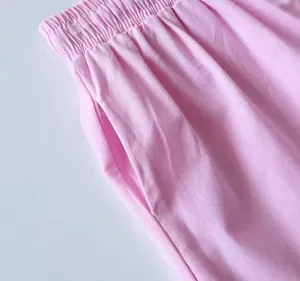 Dettaglio ravvicinato di pantaloni in cotone e lino rosa con elastico e tasca laterale