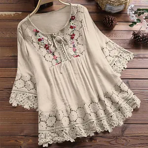 Detailweergave van de kantpatchwork en bloemenborduursels op deze boho linnen blouse.