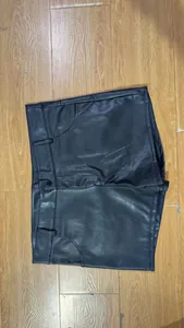 High-quality detail view of men's black PU leather shorts showing texture and stitching details