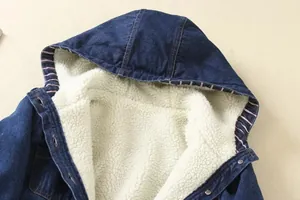 Macro view of blue denim jacket showing warm white sherpa lining and striped trim