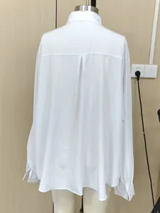 Vista posteriore di una camicia bianca oversize minimalista da donna su un manichino