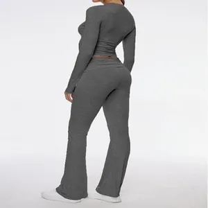 Side view detail of a gray two-piece yoga set featuring cropped top and flared pants