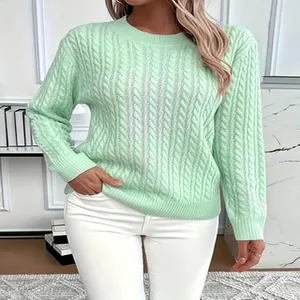 Detail view of mint green cable-knit crewneck sweater with classic braided pattern