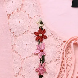 Detailopname van roze kant patchwork en bloemenborduursel op een katoenen linnen blouse