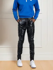 Dettaglio dei pantaloni da uomo in pelle PU nera, vestibilità slim con finitura lucida