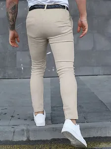 Detailed back view of men's slim-fit khaki casual trousers with white sneakers