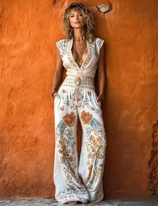Elegant white jumpsuit with orange floral prints and a deep V-neck for summer style.