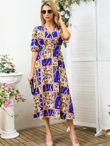 Elegant detail of vibrant blue chain print midi dress with puff sleeves and v-neck line