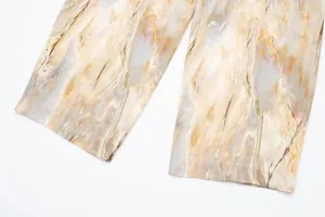 Gros plan détaillé du tissu en satin de soie imprimé tie-dye sur le pantalon droit
