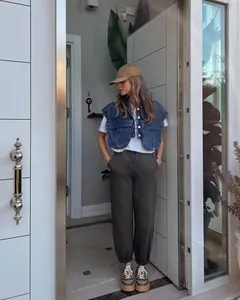 Close-up of women's cropped denim vest with large utility pockets in a street style look