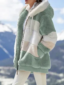 Vista laterale di una donna con giacca di peluche verde salvia e bianca con cappuccio