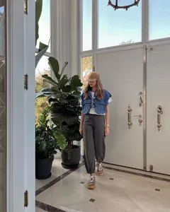 Modern casual cropped denim vest styled in a bright minimalist interior setting