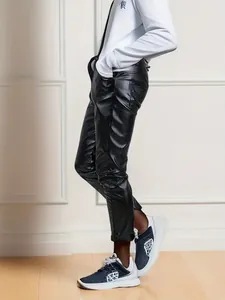 Dettaglio dei pantaloni slim da uomo in pelle PU nera con finitura lucida ed elegante