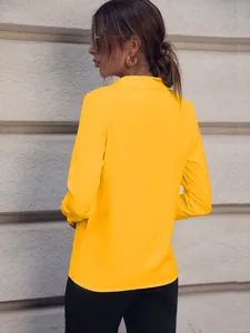 Vista trasera de una elegante camisa amarilla de manga larga para mujer de oficina.