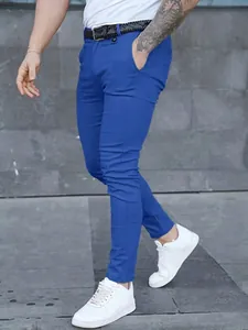 Detail view of men's slim-fit blue business casual pants styled with white sneakers on a model