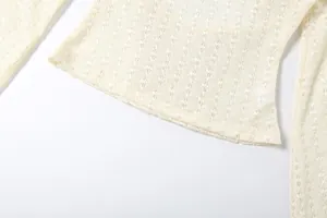 Gedetailleerde close-up van de gebreide kanten top in gebroken wit met zoomdetail